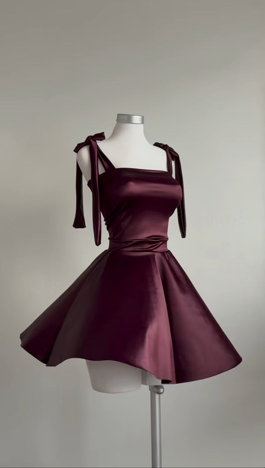 Burgundy dress on a mannequin against a plain background